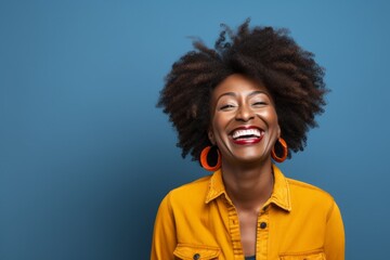 Wall Mural - Portrait of a joyful afro-american woman in her 40s smiling at the camera isolated in blank studio backdrop