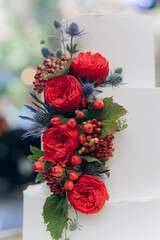 Wall Mural - the cake is covered with white cream icing and decorated with a red flower, which is served on the table