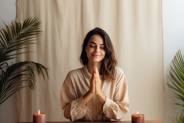 Poster - Portrait of a satisfied woman in her 30s joining palms in a gesture of gratitude isolated in light wood minimalistic setup