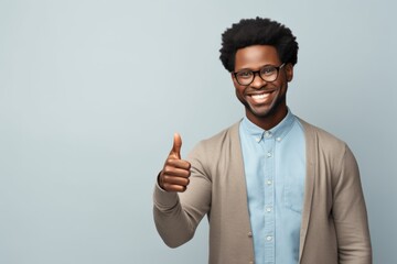 Wall Mural - Portrait of a content afro-american man in his 40s showing a thumb up over light wood minimalistic setup