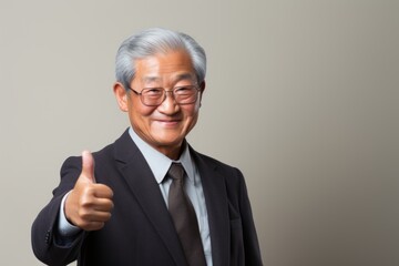 Wall Mural - Portrait of a tender asian elderly man in his 90s showing a thumb up on light wood minimalistic setup