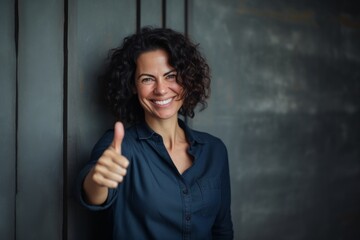 Wall Mural - Portrait of a joyful woman in her 40s showing a thumb up over empty modern loft background