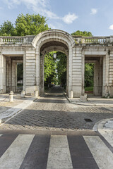 Wall Mural - A cobblestone road passing under a vintage building with arches and passages