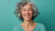 © justholla - Cheerful older woman with grey curls, contemporary minimalism, solid teal background, soft daylight, casual wear