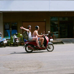 Poster - Freedom, happy couple and drive scooter in city for travel, journey and holiday vacation together outdoor on road trip. Man, woman and ride bike for transport, blur and fast speed on street adventure