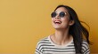 © PeopleWorker - Portrait of a beautiful young asian woman laughing and looking up over yellow background