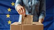 © Business Pics - Voting concept - Ballot box on the European Union flag background. Election in European Union. Woman putting her vote in the ballot box.