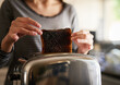 © peopleimages.com - Hands, woman and burnt toast for breakfast in kitchen as cooking disaster, fail and accident as mistake in morning. Frustrated, person and black bread for unhealthy, electrical problem or safety