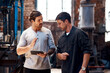 © peopleimages.com - Tablet, manufacturing and men in workshop for blacksmith planning or blue collar trade in small business. Teamwork, research or metal workers in factory on technology for production or steel industry