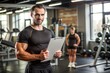 © Евгений Порохин - A man is holding a clipboard in a gym with a woman standing behind him