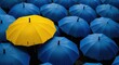 © lal khan - A yellow umbrella that stands out among the blue ones