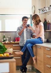 Poster - Happy, couple cooking and drinking together for bonding in kitchen over romantic meal preparation at home. Excited, man and woman with wine glasses and cutting board for nutrition and healthy food