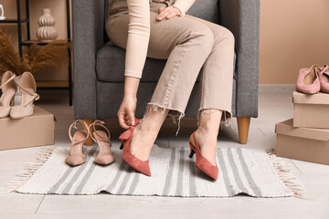 Sticker - Young woman trying on new red shoes with open heel at home