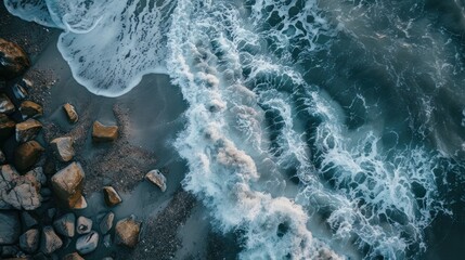 Wall Mural - An aerial view captures the dramatic moment as sea waves crash against rocks on the beach