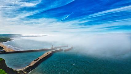 Wall Mural - Aerial view of coastal pier with lighthouse and fog in Whitby, North Yorkshire