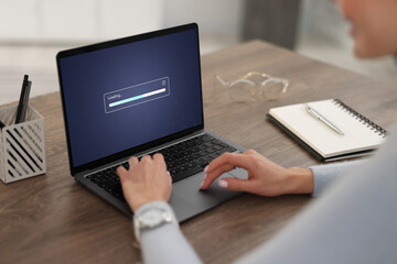Loading screen displaying progress. Woman working on laptop at table indoors, closeup