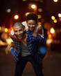 © peopleimages.com - Happy, couple and piggyback in city at night on adventure or excited to travel on journey together. People, walking and woman with support of partner in marriage, laughing and explore town on date