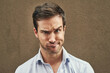 © peopleimages.com - Man, portrait or funny face on isolated background in silly, goofy or comedy on mockup or wall backdrop. Comic, emoji or happy comedian guy in quirky pose, joke style trend or facial expression