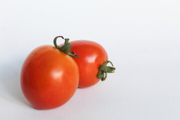 Portrait of two fresh tomatoes on a white background