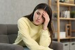© New Africa - Overwhelmed woman sitting in armchair at home