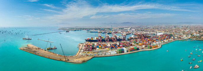 Aerial view of the port of Callao in Lima, Peru, showing port activity with containers and cranes in full operation. In the background can be seen the city and the Pacific Ocean