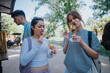 © qunica.com - Two young women savor ice cream cones, sharing a joyful moment together in a sunny park, embodying friendship and relaxation.