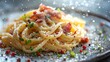 © kang_88_qp - A plate of pasta carbonara. The pasta is topped with crispy bacon, a creamy sauce, and a generous amount of grated cheese.