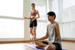 © Kawee - Asian young amputee without arm doing yoga with trainer in fitness gym.