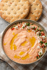 Wall Mural - Htipiti or Tirokafteri a delicious Greek feta and roasted red pepper dip closeup on the bowl on the table. Vertical top view from above