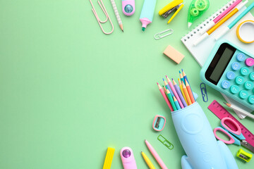 Wall Mural - Back to school concept. School and office supplies on a vivid green background, ideal for educational and professional creative project.