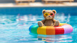 © Atlantist studio - A cute teddy bear wearing sun glasses, sitting on an inflatable rainbow ring in the swimming pool at a summer vacation camp. A colorful rubber swim tube for children to float