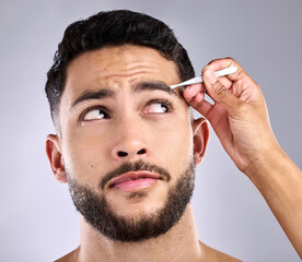 Sticker - Model, cleaning and tweezers for eyebrows on face in studio, selfcare and grooming. Man, hygiene and person with clippers for hair removal for maintenance, wellness and treatment in grey background