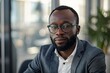 © gankevstock - Confident young businessman wearing glasses in a modern office environment