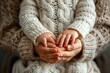 © Sandu - Person holding baby's hands in cozy sweater