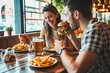© Anjali Snap - Happy couple eating burger sitting at pub restaurant fast food table - Young people having lunch break at cafe bar venue - Life style concept with guy, Generative AI
