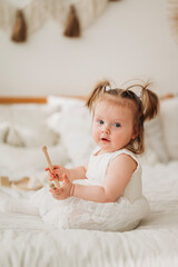 Wall Mural - Cute adorable baby girl in white dress indoors closeup portrait Happy childhood funny kid