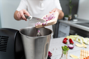 Home Cooking: Man Adding Chopped Onion to Food Processor