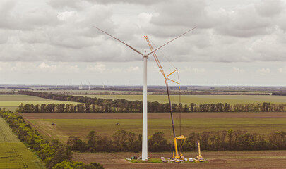 Wall Mural -  construction wind turbine park for green energy future with zero carbon footprint. Wind turbine construction Aerial view.