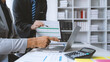 ©  NCST Studio - Business representatives meeting pointing on laptop computer. Business team discussing investment plan using data on laptop.