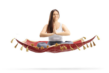 Wall Mural - Young female in pajamas floating on a magic carpet and meditating