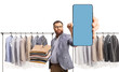 © Ljupco Smokovski - Man with a pile of folded clothes at a dry cleaners holding a smartphone