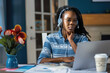 © kmlPhoto - A woman wearing headphones is using a laptop computer
