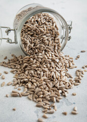 Wall Mural - Raw healthy sunflower seeds in glass jar on white kitchen table.Macro.