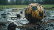 © buraratn - worn-out soccer ball lying on a muddy field after a rainy game