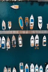 Wall Mural - Aerial view of a minimalist marina with neatly arranged boats and docks. Focus on the clean lines and repetitive patterns, using a limited color palette to enhance the minimalist aesthetic. 