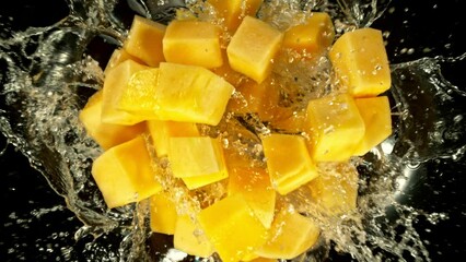 Aufkleber - Super Slow Motion of Falling Mango Slices into Water, Black Background. Filmed on High Speed Cinema Camera, 1000 fps. Camera Tracking the Target.