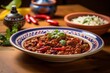 © Markus Schröder - Hearty chili con carne on a porcelain platter against a colorful tile background
