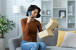 © Tetiana - Woman on phone receiving wrong product delivery at home, feeling confused