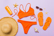 © sosiukin - Woman swimwear and beach accessories flat lay top view. Top view with bikini outfit on color background. Vacation concept copy space