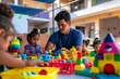 © Yuliia - Young male Hispanic teacher facilitating learning activities with diverse group of preschool students using educational toys in classroom.